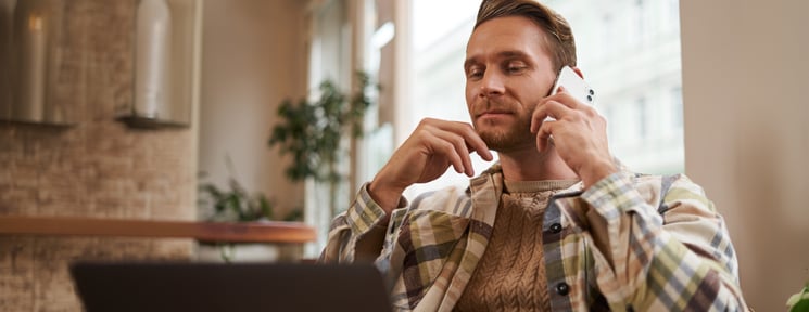 image-young-professional-cafe-visitor-working-sitting-with-laptop-talking-mobile-phone-client-guy-making-enquiry-buying-something-online-calling-friend